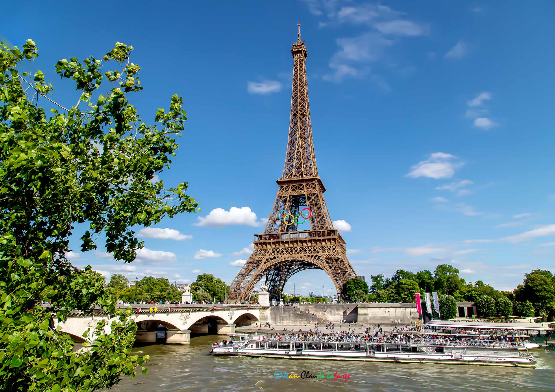 La tour Eiffel ornée de ses Anneaux Olympiques bleu, jaune, noir, vert et rouge.