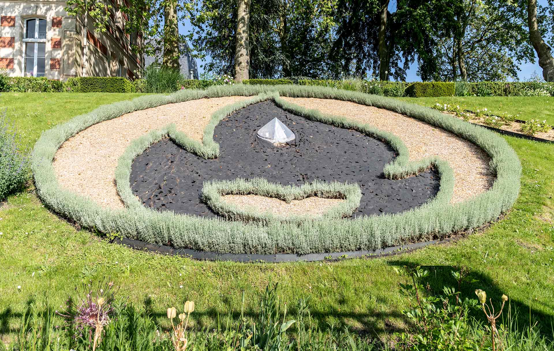 Parterre de fleurs en forme de Flamme des JO 2024 dans les Jardins de l'hôtel de Villes de Versailles. La Flamme passera à Versailles le 23/07/2024.